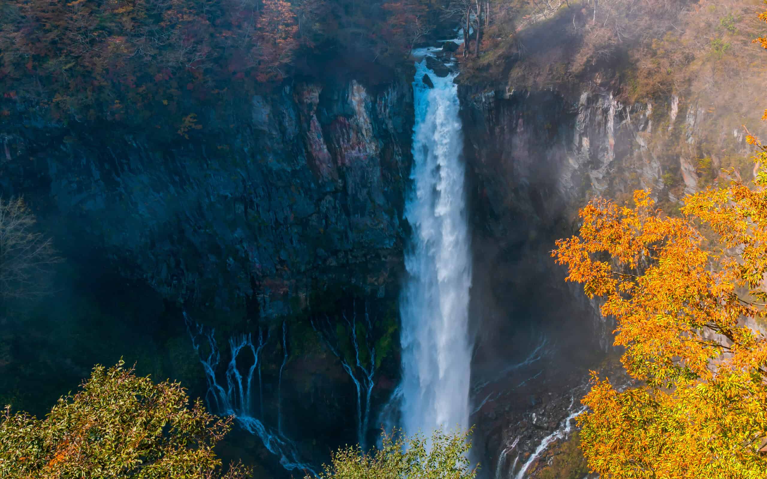 View of Kegon Waterfall at the cliff of colorful foliage of autumn season forest on the mountain in Nikko City, Tochigi Prefecture, Japan.